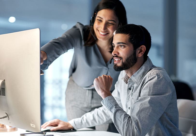 A man and woman looking at the computer screen.